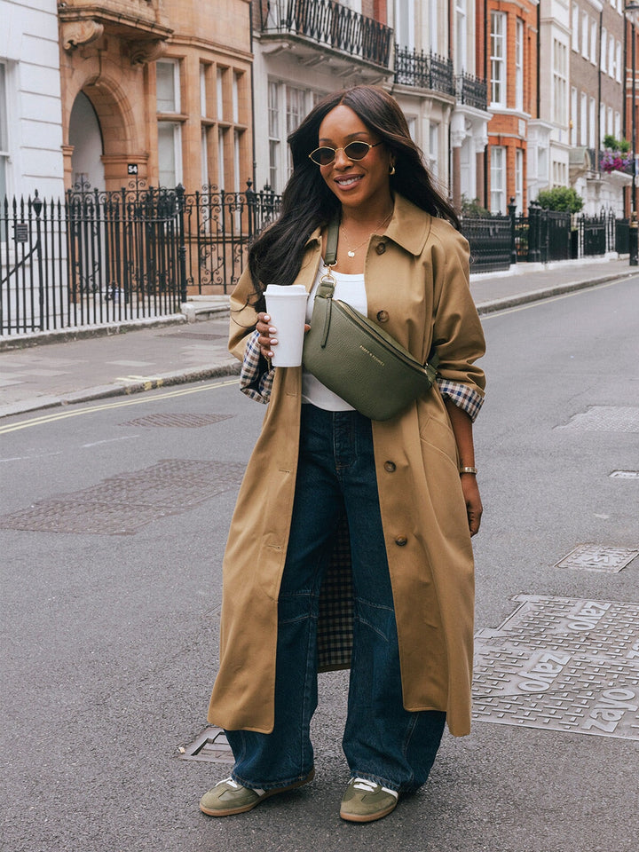 Woman standing with the Poppy & Peonies The Sidekick in Olive worn as a crossbody on a city street.