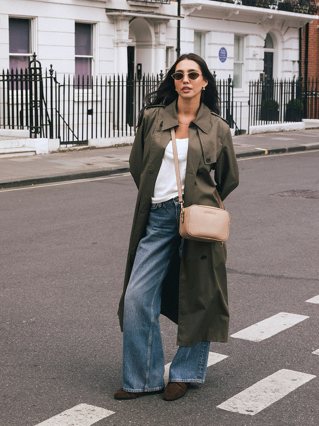 Woman standing with the Poppy & Peonies 24/7 Crossbody in Taupe worn across her body on a city street.