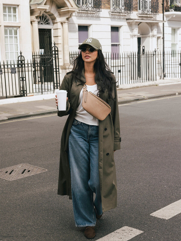 Woman walking with the Poppy & Peonies The Sidekick in Taupe worn across her chest while holding a takeaway cup.