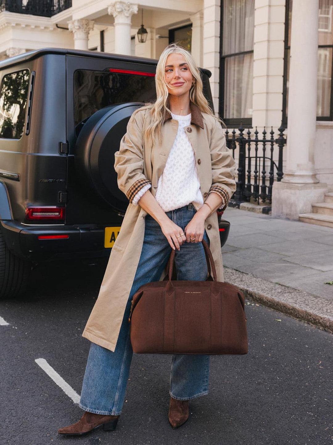 Poppy & Peonies Take Off Tote in Espresso Suede carried by the top handles outdoors, showcasing its spacious structured shape and soft suede finish.