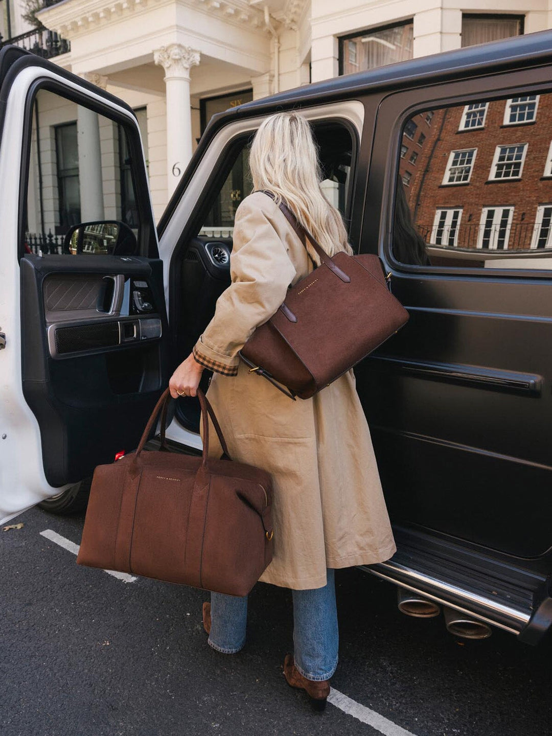 Poppy & Peonies Take Off Tote in Espresso Suede carried by hand with the Avenue Tote in Espresso Suede worn separately over the shoulder, highlighting its versatile travel organization.