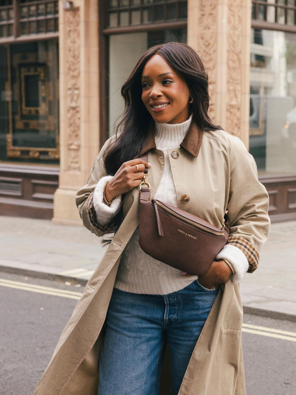 Lifestyle shot of a woman wearing the Poppy & Peonies Sidekick in Espresso crossbody while walking along a city street.