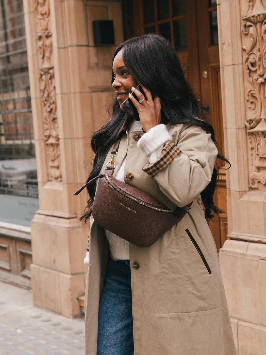 Lifestyle shot of a woman wearing the Poppy & Peonies Sidekick in Espresso crossbody while talking on her phone.