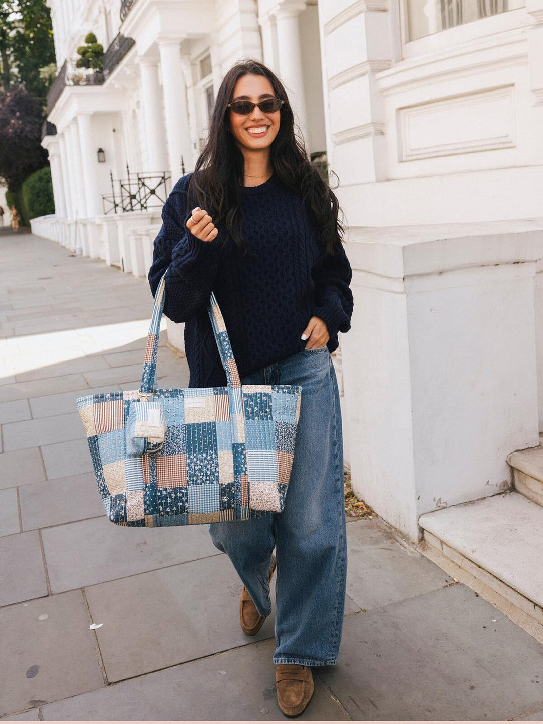 Woman walking with the Poppy & Peonies Daydreamer Tote in Navy Patchwork carried by the top handles