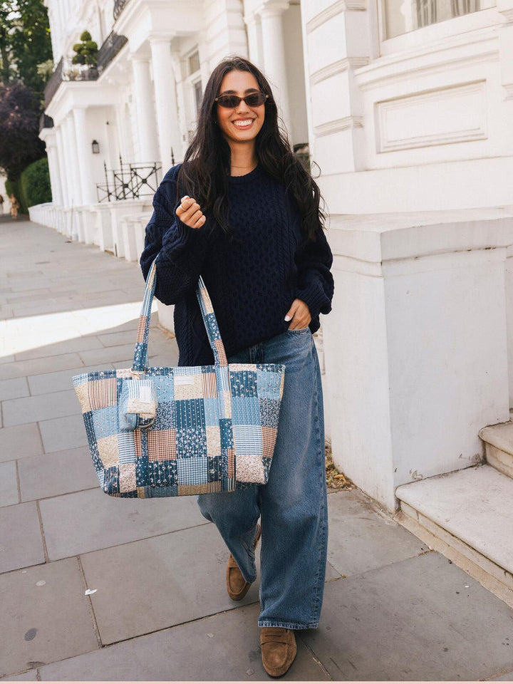 Woman walking with the Poppy & Peonies Daydreamer Tote in Navy Patchwork carried by the top handles