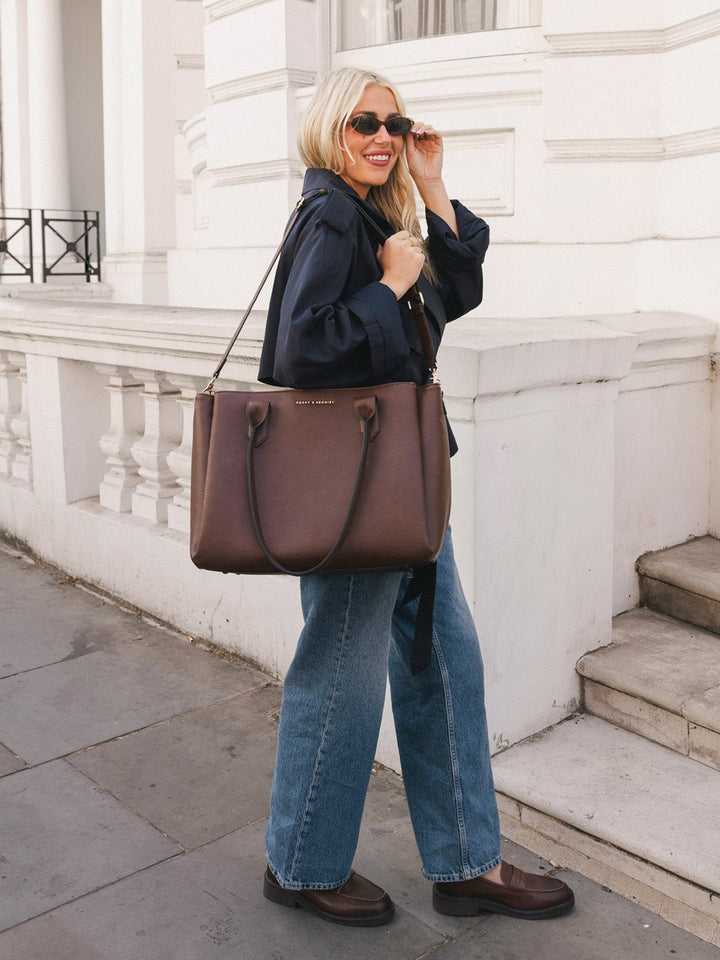 Woman carrying the Poppy & Peonies Double Duty Tote in Espresso with the removable crossbody strap.