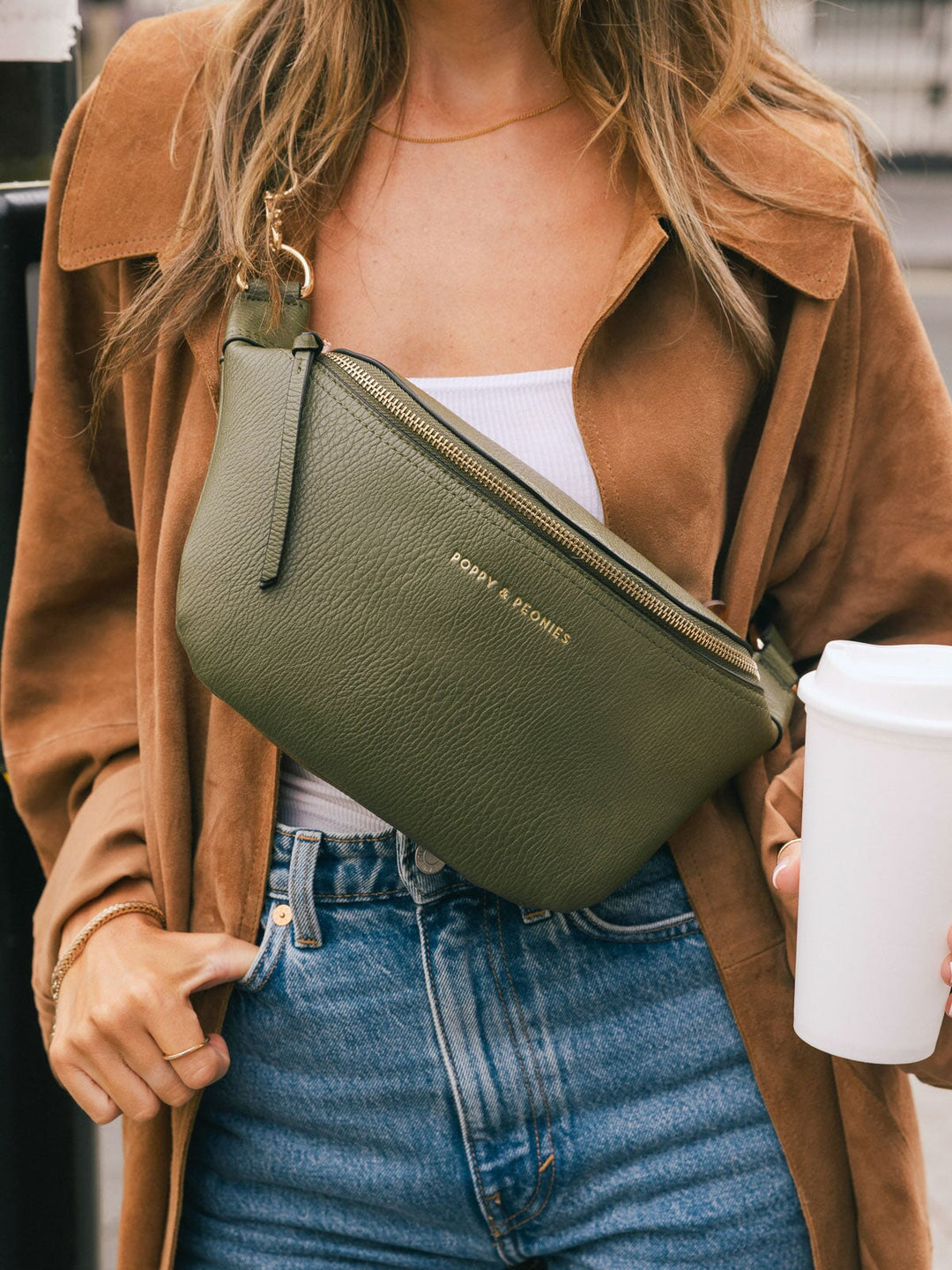 Close-up of the Poppy & Peonies Sidekick in Olive worn crossbody with a brown coat and jeans.