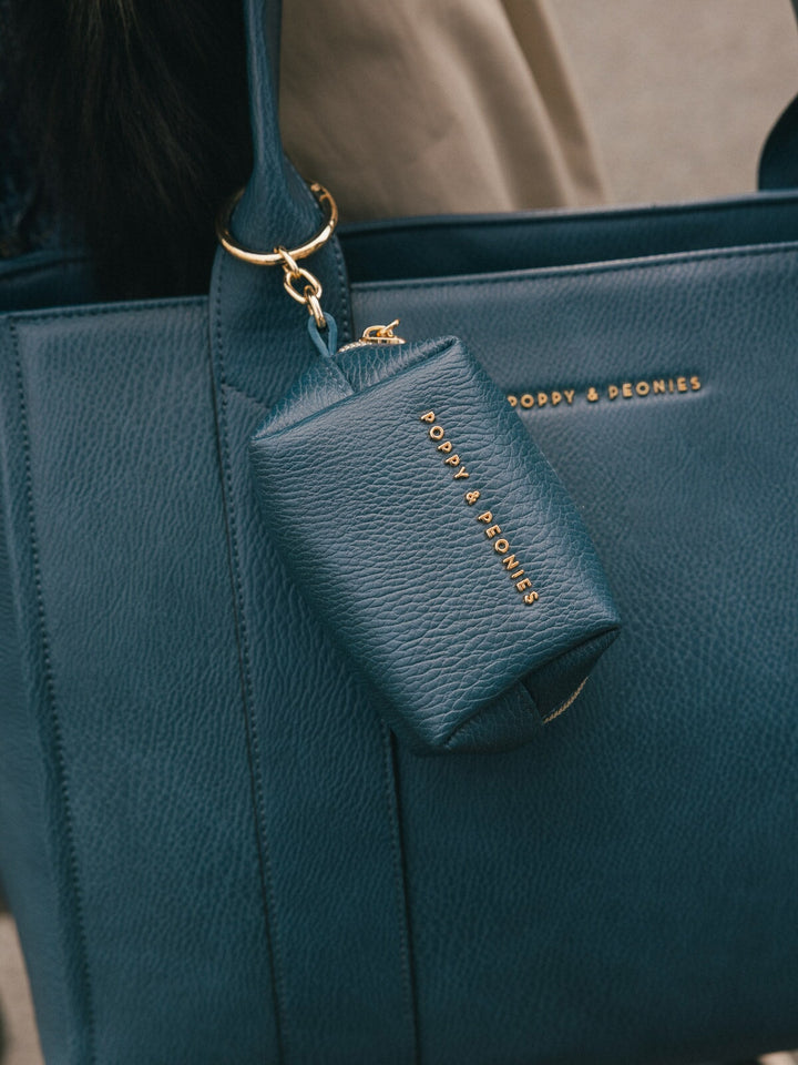 Close-up detail of the Poppy & Peonies Multitasker in Navy, featuring the matching accessory pouch and gold-tone hardware.