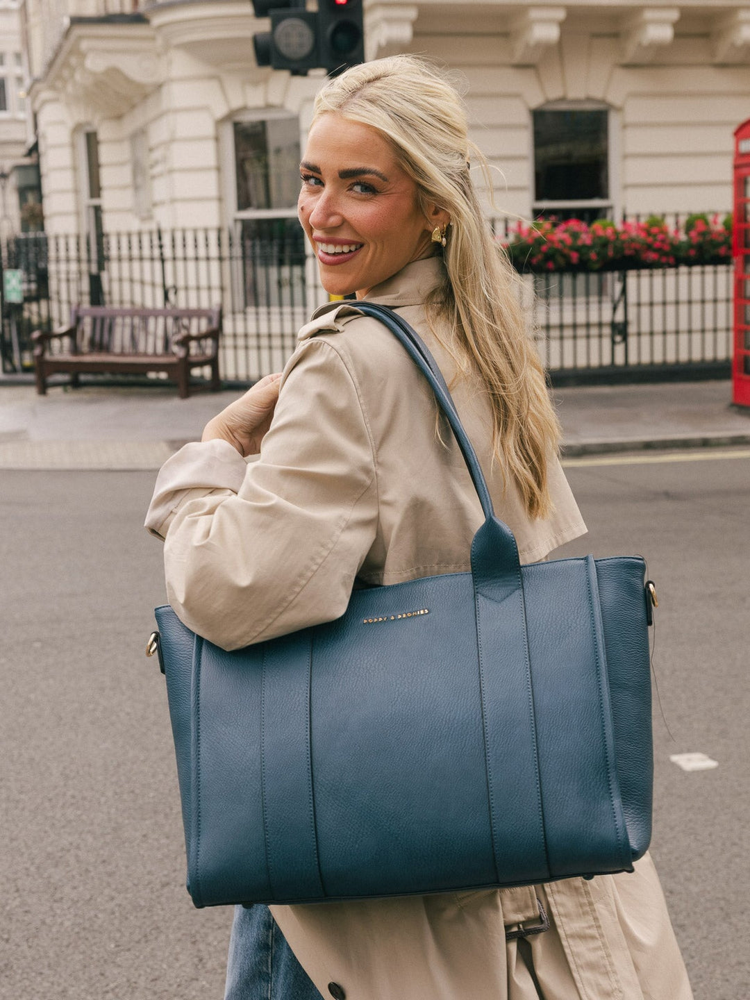 Closer lifestyle shot of a woman carrying the Poppy & Peonies Multitasker in Navy over her shoulder.