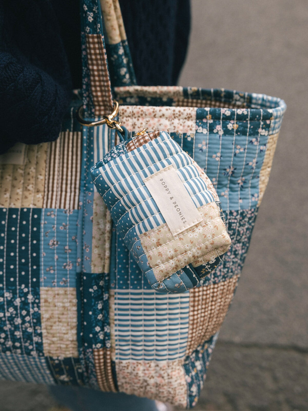Close-up detail of the Poppy & Peonies Daydreamer Tote in Navy Patchwork, showing the patchwork print and matching accessory pouch.