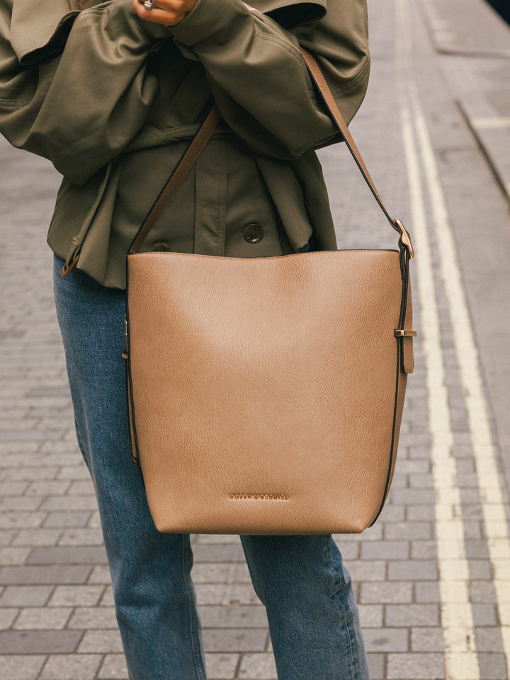 Front-facing product-focused shot of the Poppy & Peonies Bucket Bag in Taupe worn crossbody.