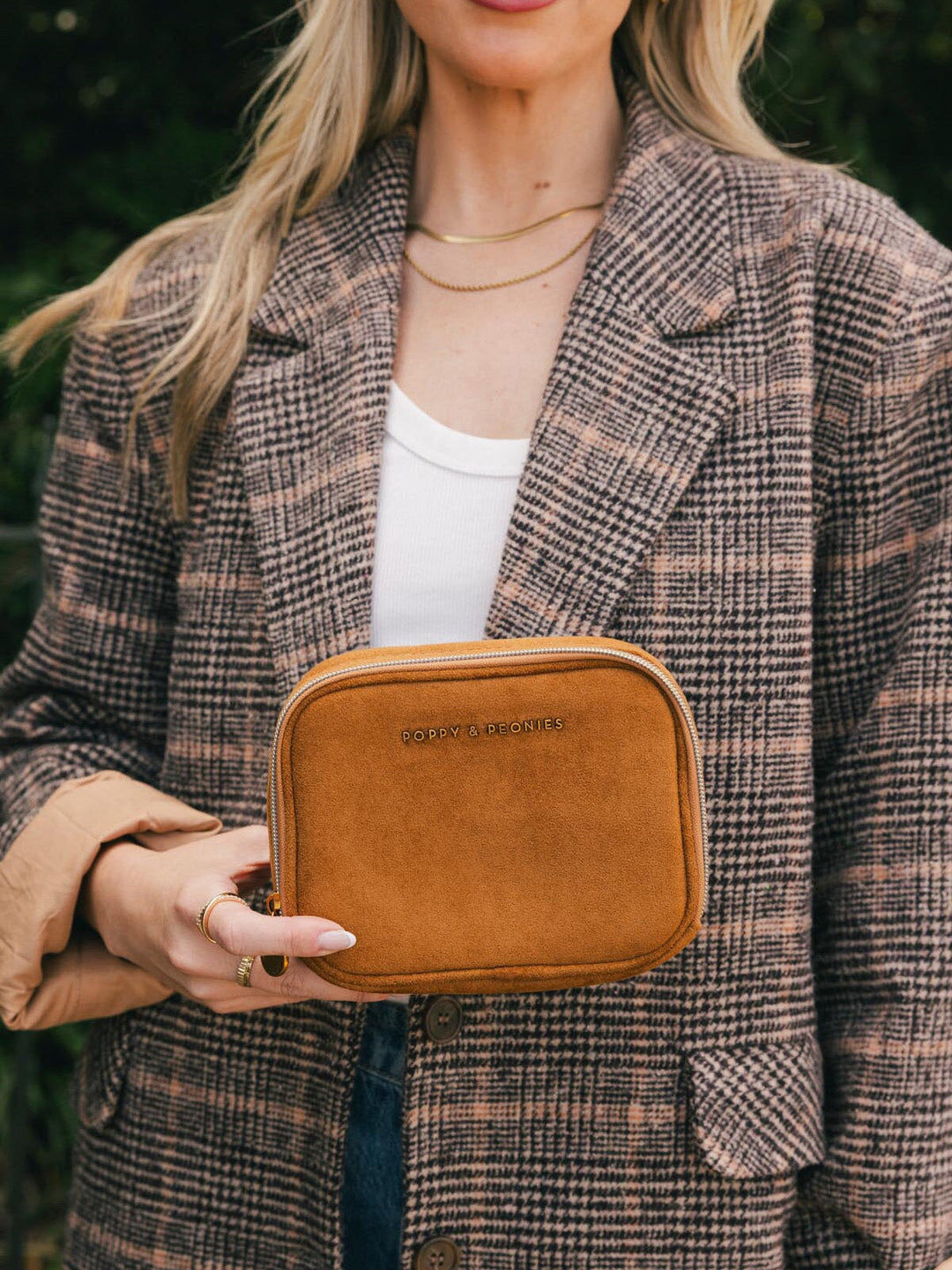 Poppy & Peonies Pretty Connected Case in Cognac Suede held in hand outdoors, showing its compact size and structured shape.