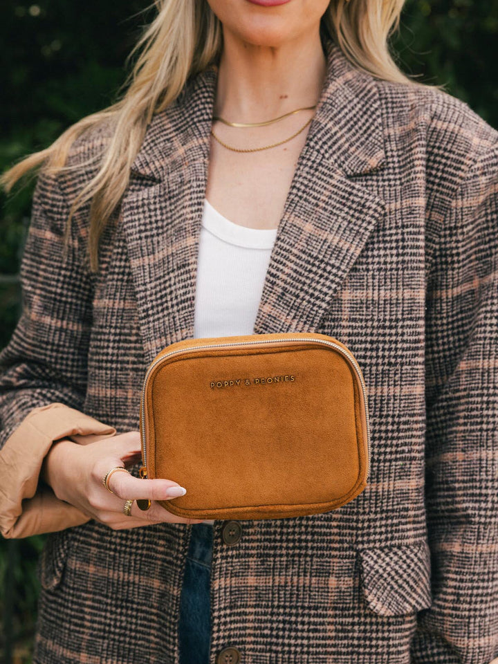 Poppy & Peonies Pretty Connected Case in Cognac Suede held in hand outdoors, showing its compact size and structured shape.