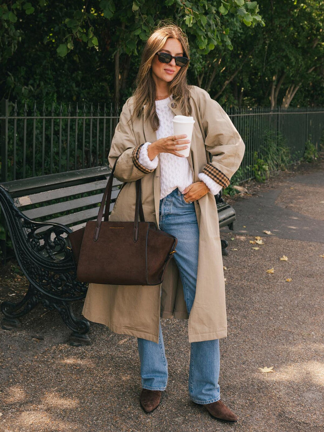 Poppy & Peonies Mini Avenue Tote in Espresso Suede carried by the top handles outdoors, highlighting its soft suede exterior and comfortable strap drop.