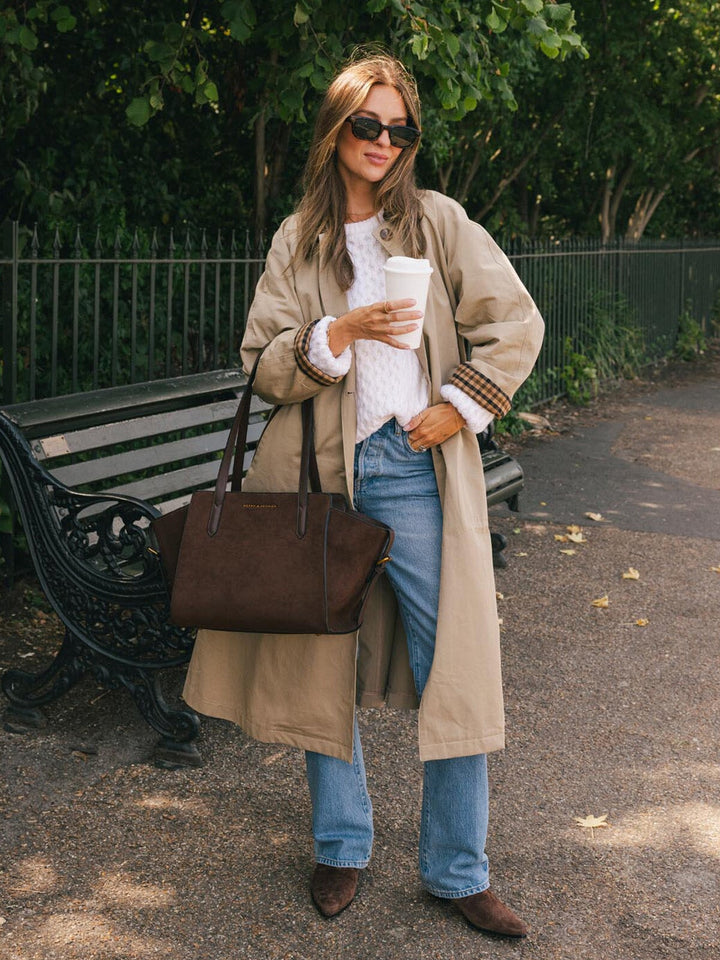 Poppy & Peonies Mini Avenue Tote in Espresso Suede carried by the top handles outdoors, highlighting its soft suede exterior and comfortable strap drop.