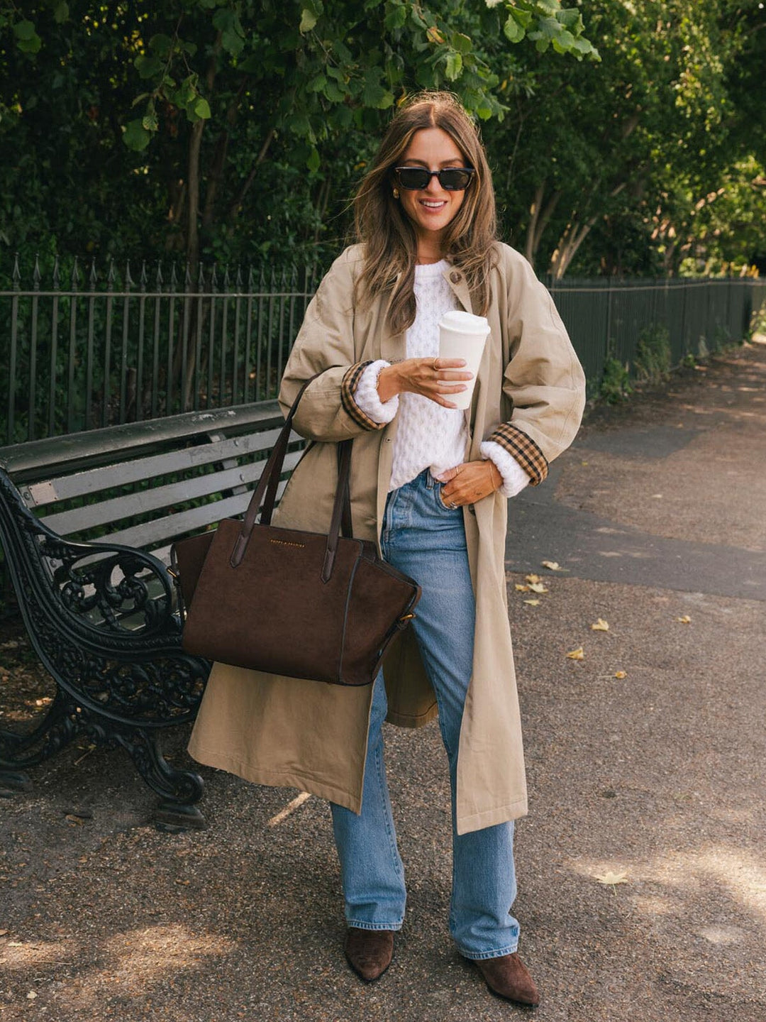 Poppy & Peonies Mini Avenue Tote in Espresso Suede carried by the top handles during a casual park outing, showcasing its compact tote silhouette and smooth vegan leather straps.