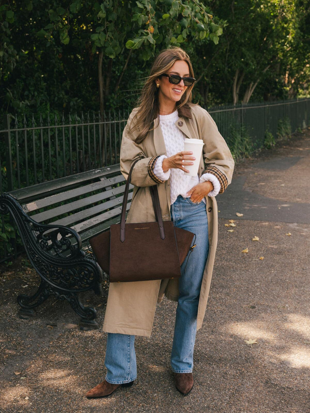 Peonies Mini Avenue Tote in Espresso Suede carried by hand while holding a coffee outdoors, highlighting its soft suede body and structured top handles.