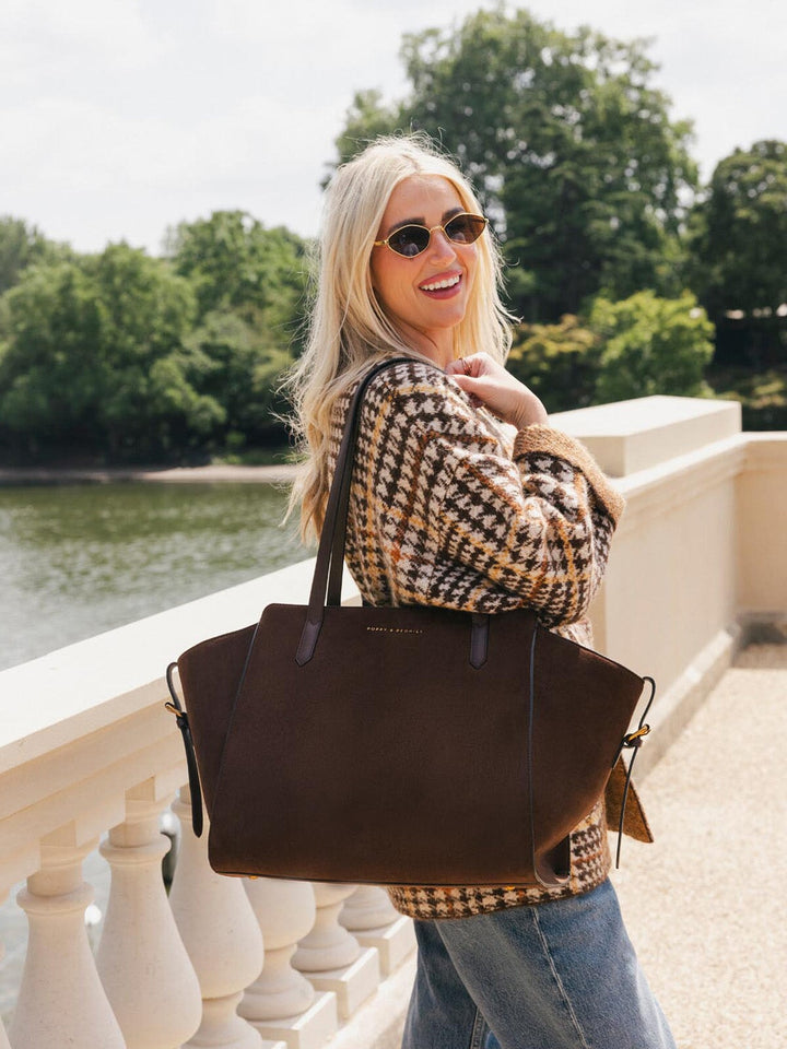 Poppy & Peonies Avenue Tote in Espresso Suede worn comfortably over the shoulder outdoors, highlighting its roomy design and soft suede body.
