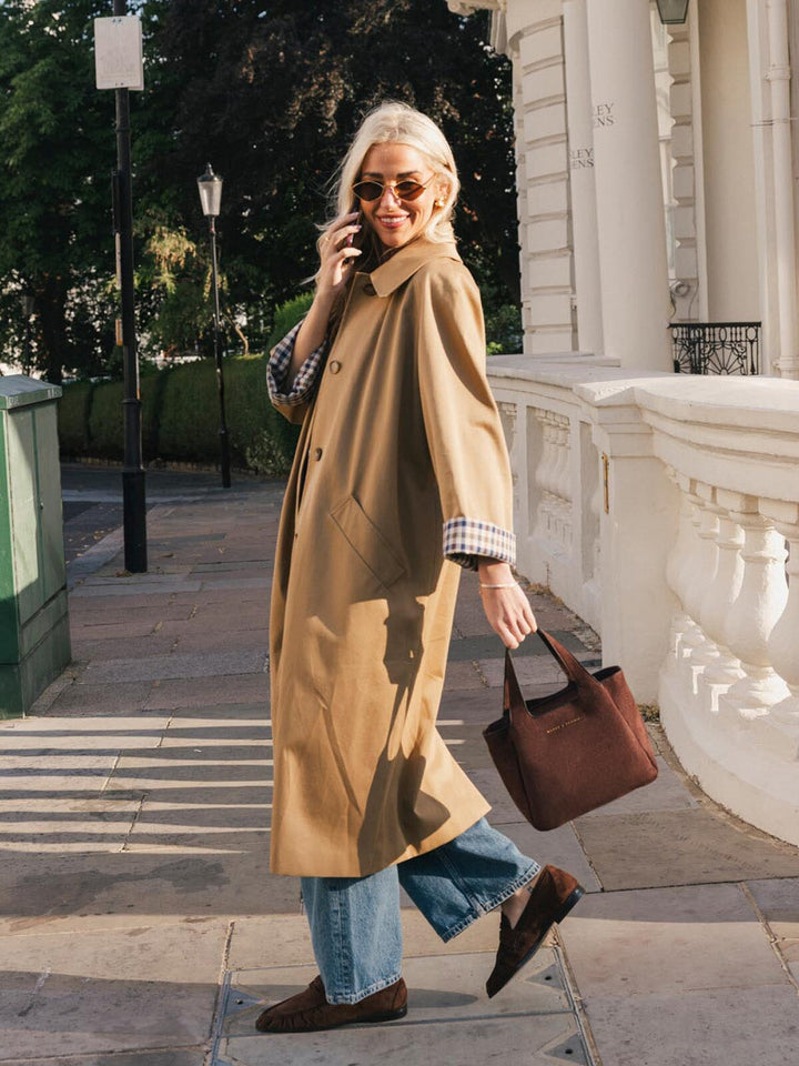 Poppy & Peonies The Pick Me Up Tote in Espresso Suede carried by the top handles during a sunny outdoor outing.