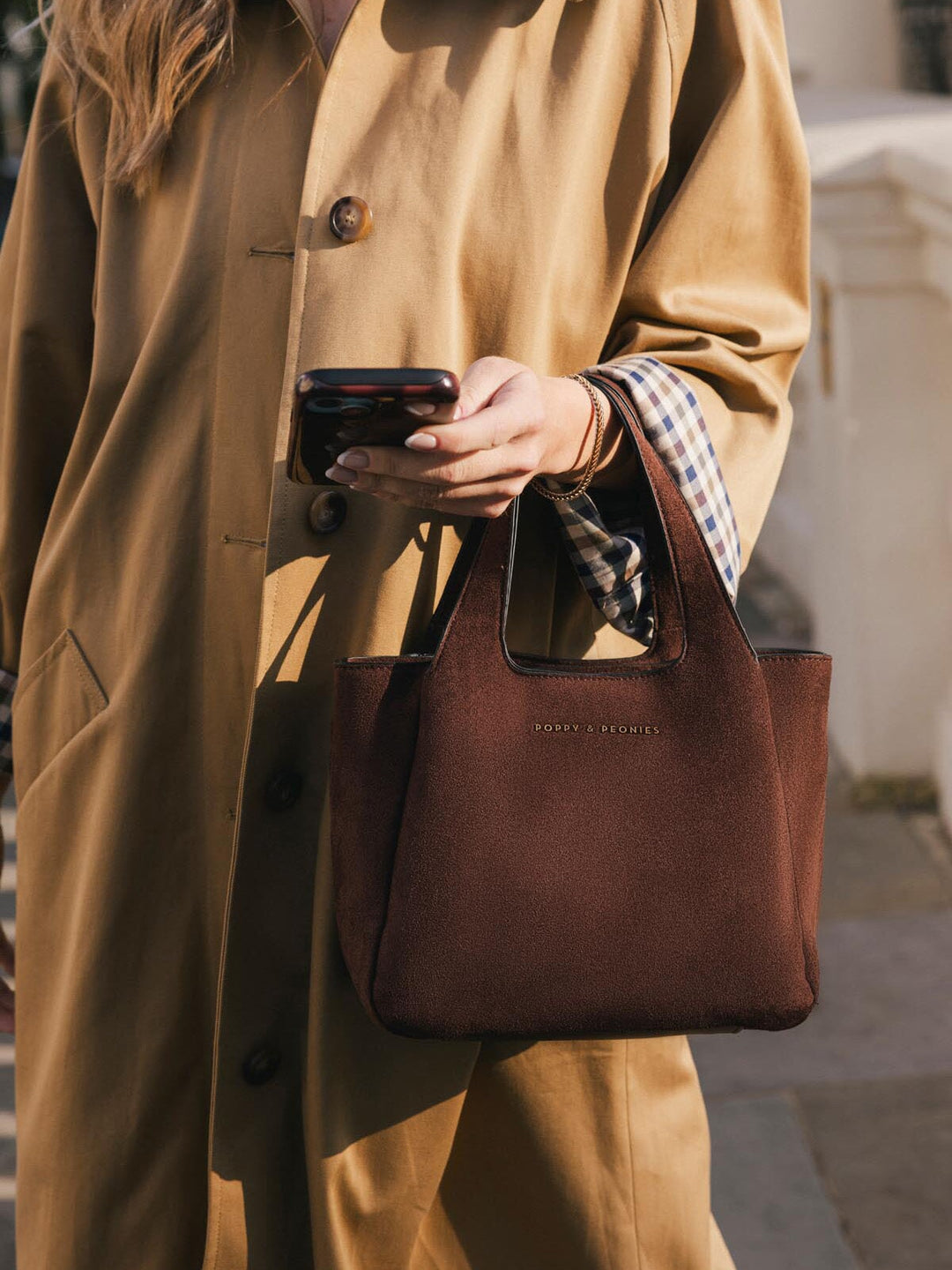 Close-up of Poppy & Peonies The Pick Me Up Tote in Espresso Suede carried by hand, showing the top handles and soft brown suede exterior.
