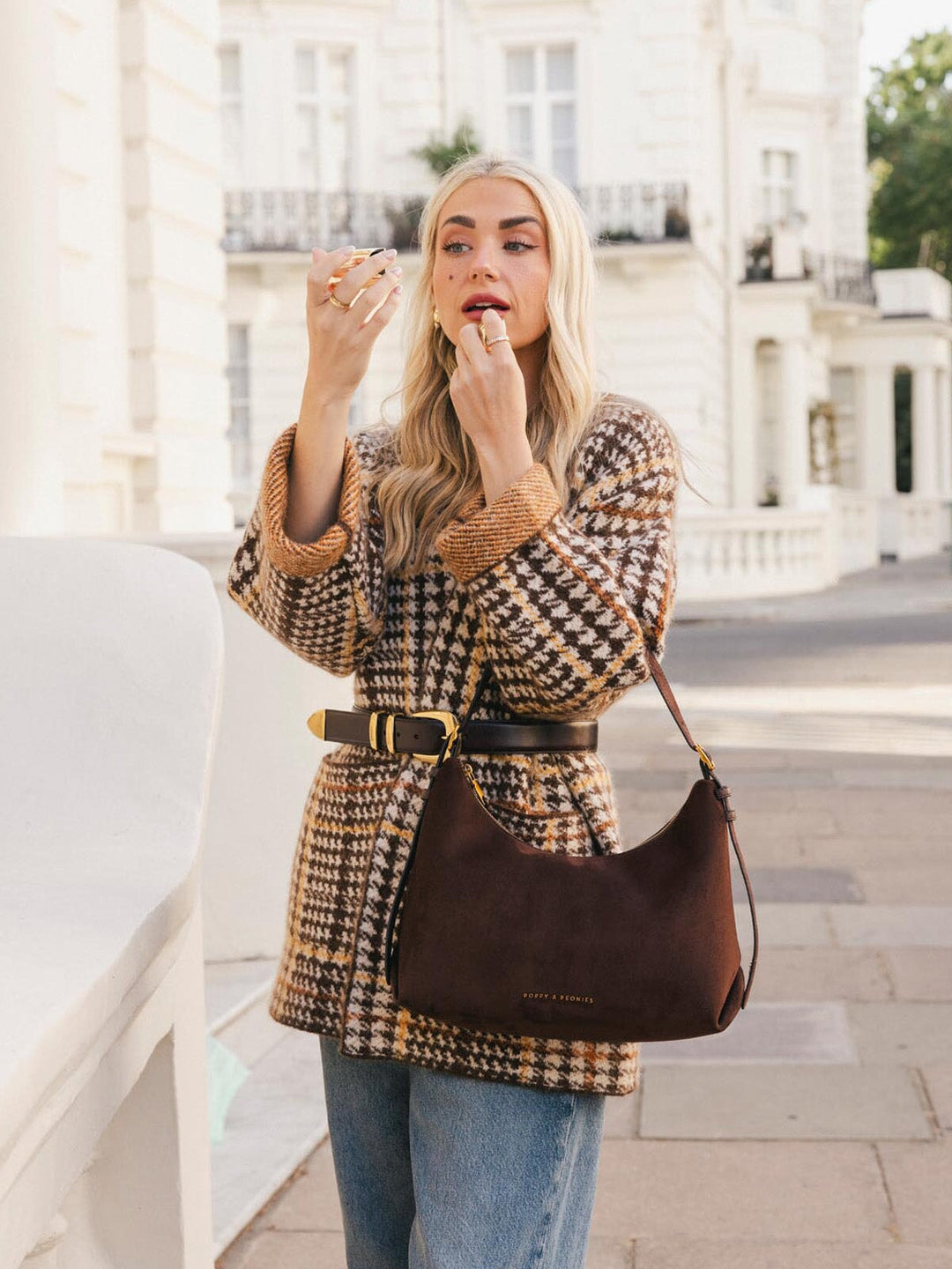 Poppy & Peonies The Sunday Bag in Espresso Suede carried at the front, showcasing its soft suede exterior and relaxed curved shape.