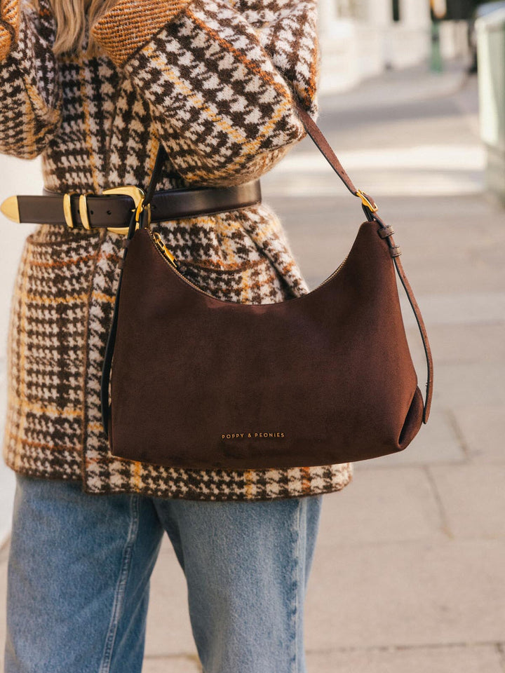 Close-up of Poppy & Peonies The Sunday Bag in Espresso Suede worn over the shoulder, showcasing its soft suede texture and curved silhouette.