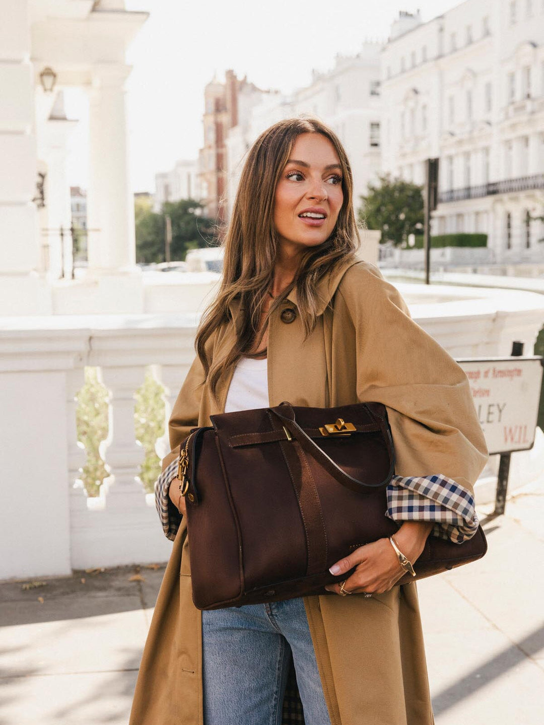 Poppy & Peonies Effortless Tote in Espresso Suede held against the body outdoors, highlighting its roomy shape, top handles and turn-lock belting detail.