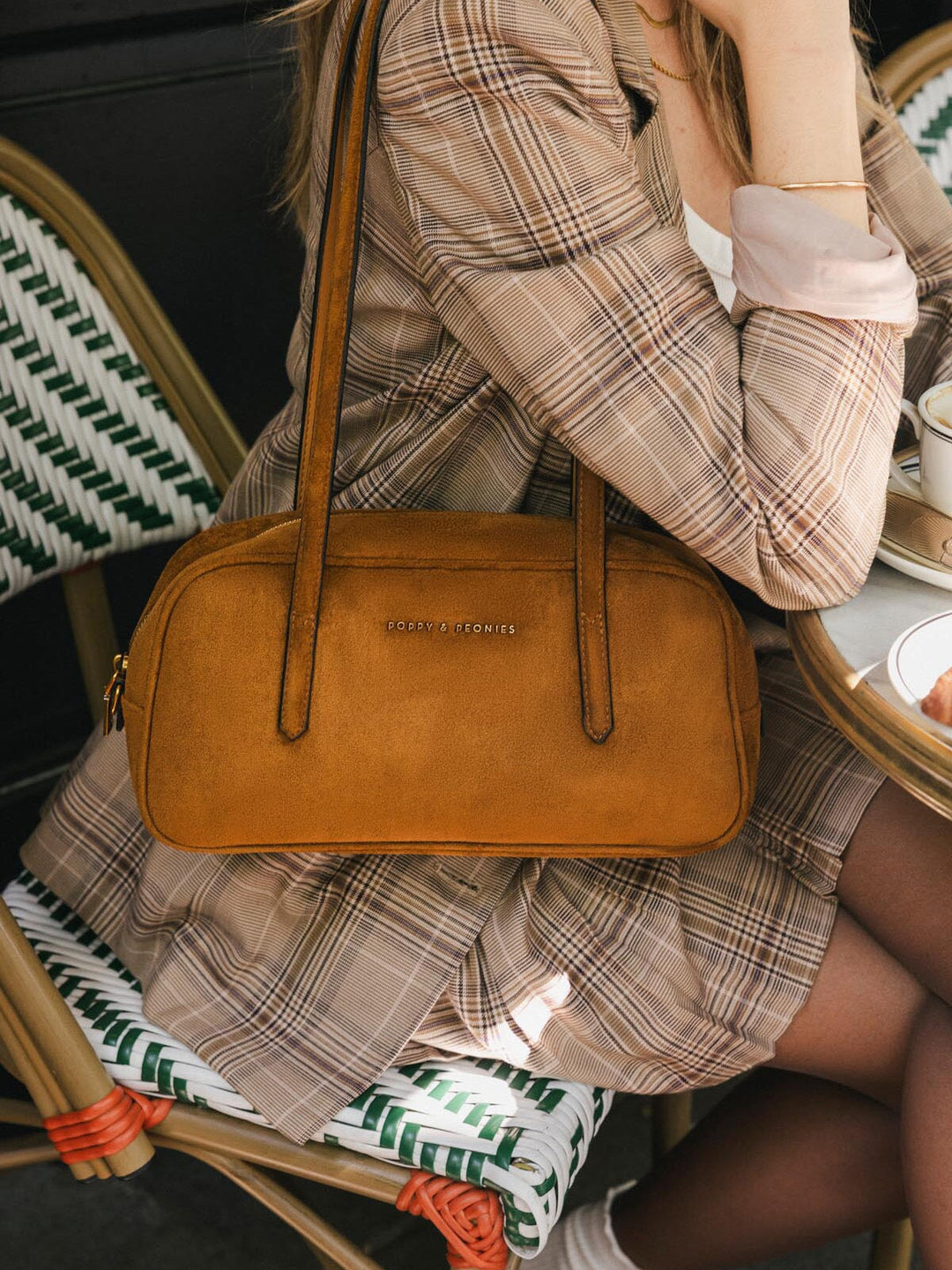 Close-up of Poppy & Peonies The Friday Satchel in Cognac Suede, showcasing its elongated east-west silhouette and structured top handles.