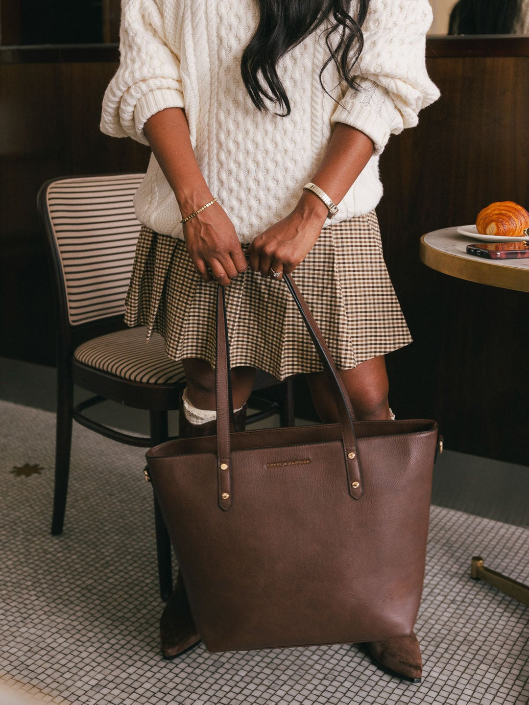 Close-up product-focused shot of the Poppy & Peonies Go-Getter Tote in Espresso held by its shoulder straps, highlighting the spacious silhouette.