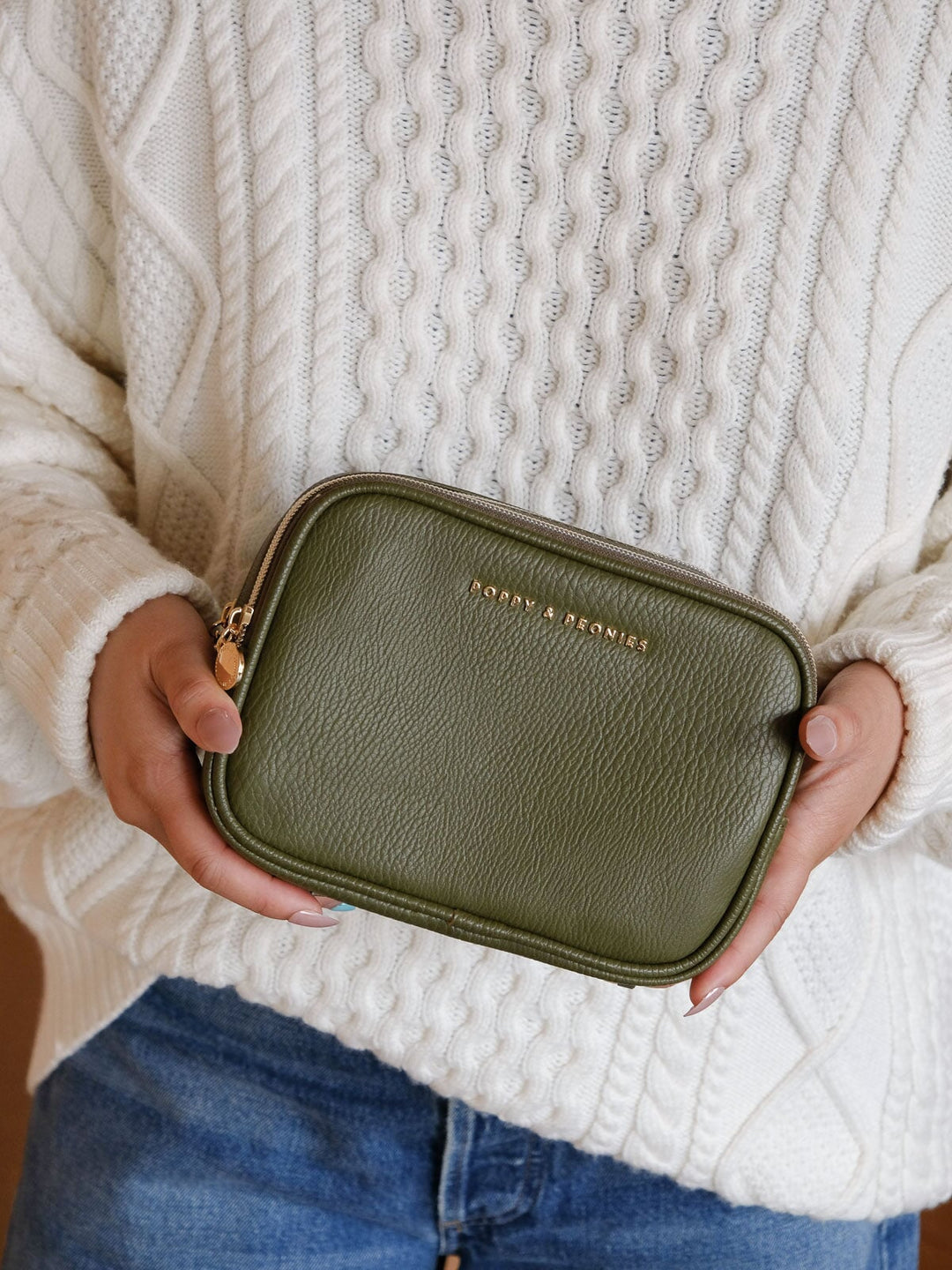 Close-up lifestyle shot of a woman holding the Poppy & Peonies Split Organizer in Olive, showcasing its structured silhouette and textured finish.
