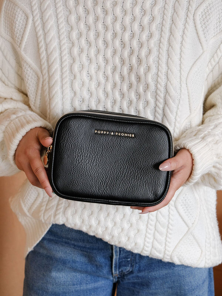 Lifestyle close-up of the Split Organizer in Black, highlighting its structured silhouette, black textured exterior, and zip-around closure.