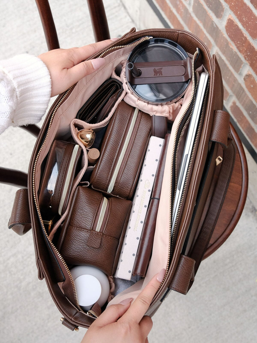 Overhead lifestyle shot of the Multitasker in Espresso packed with everyday essentials, highlighting its roomy interior, dedicated compartments, and organizational pockets.