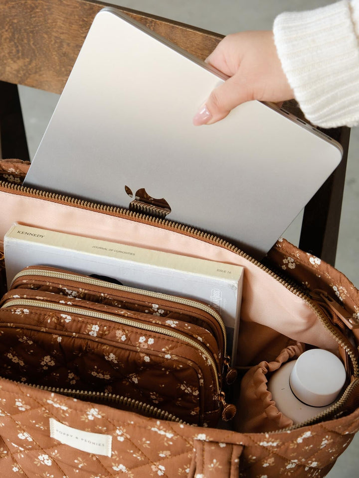 Interior lifestyle shot of the Daydreamer Tote in Brown Floral highlighting its roomy design with space for a laptop, cosmetic cases, books, and everyday essentials.
