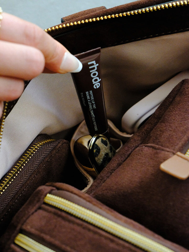Poppy & Peonies Bag Interior in Espresso Suede interior close-up, highlighting blush organizational pockets holding beauty essentials and small accessories.