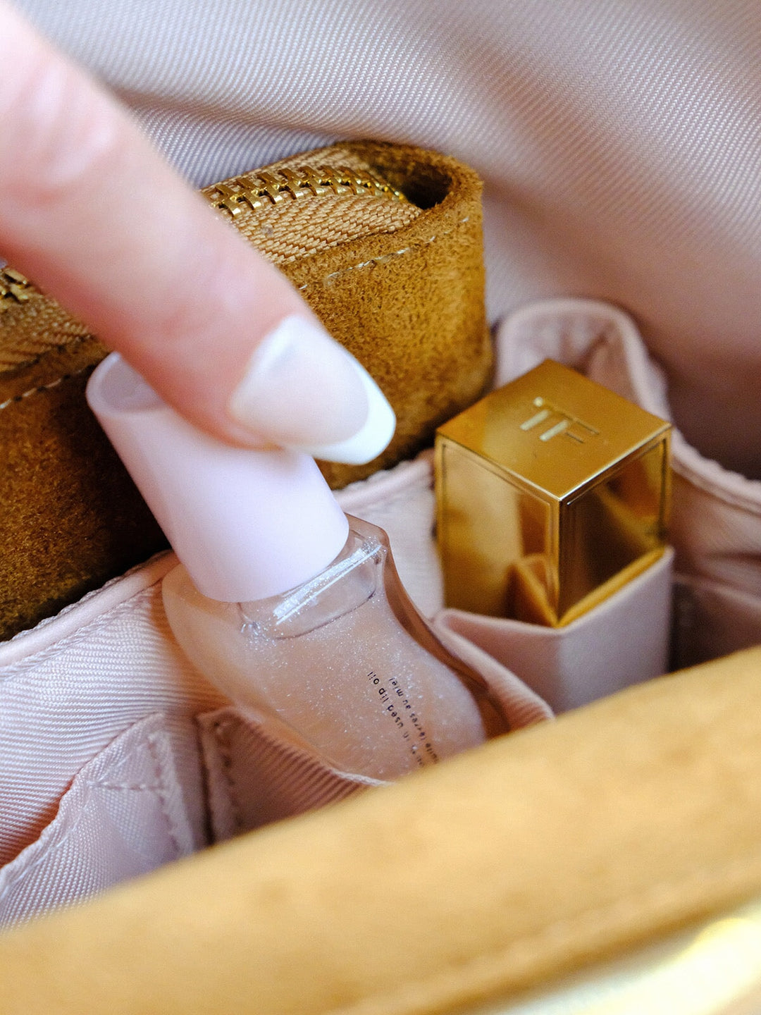 Poppy & Peonies Avenue Tote in Cognac Suede interior close-up, featuring blush organizational pockets holding beauty essentials.