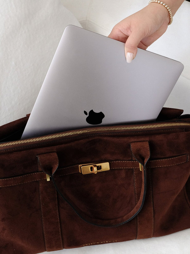 Poppy & Peonies Effortless Tote in Espresso Suede open with a laptop being placed inside, showcasing the spacious interior and top zip closure.