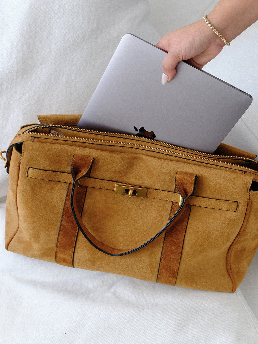 Poppy & Peonies Effortless Tote in Cognac Suede open with a laptop being placed inside, showcasing the spacious interior and top zip closure.