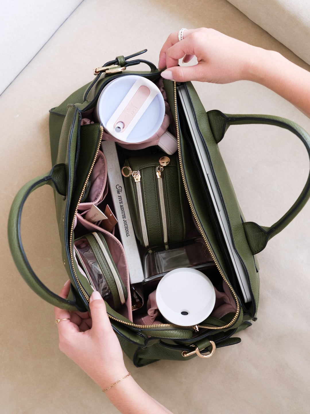 Top-down lifestyle shot of the Uptown Tote in Olive highlighting its organized interior compartments and generous storage for daily essentials.