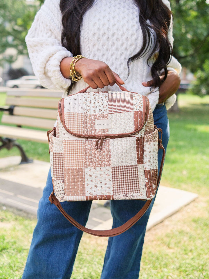 Poppy & Peonies The Lunch Date in Brown Patchwork carried by the top handle with the shoulder strap attached.