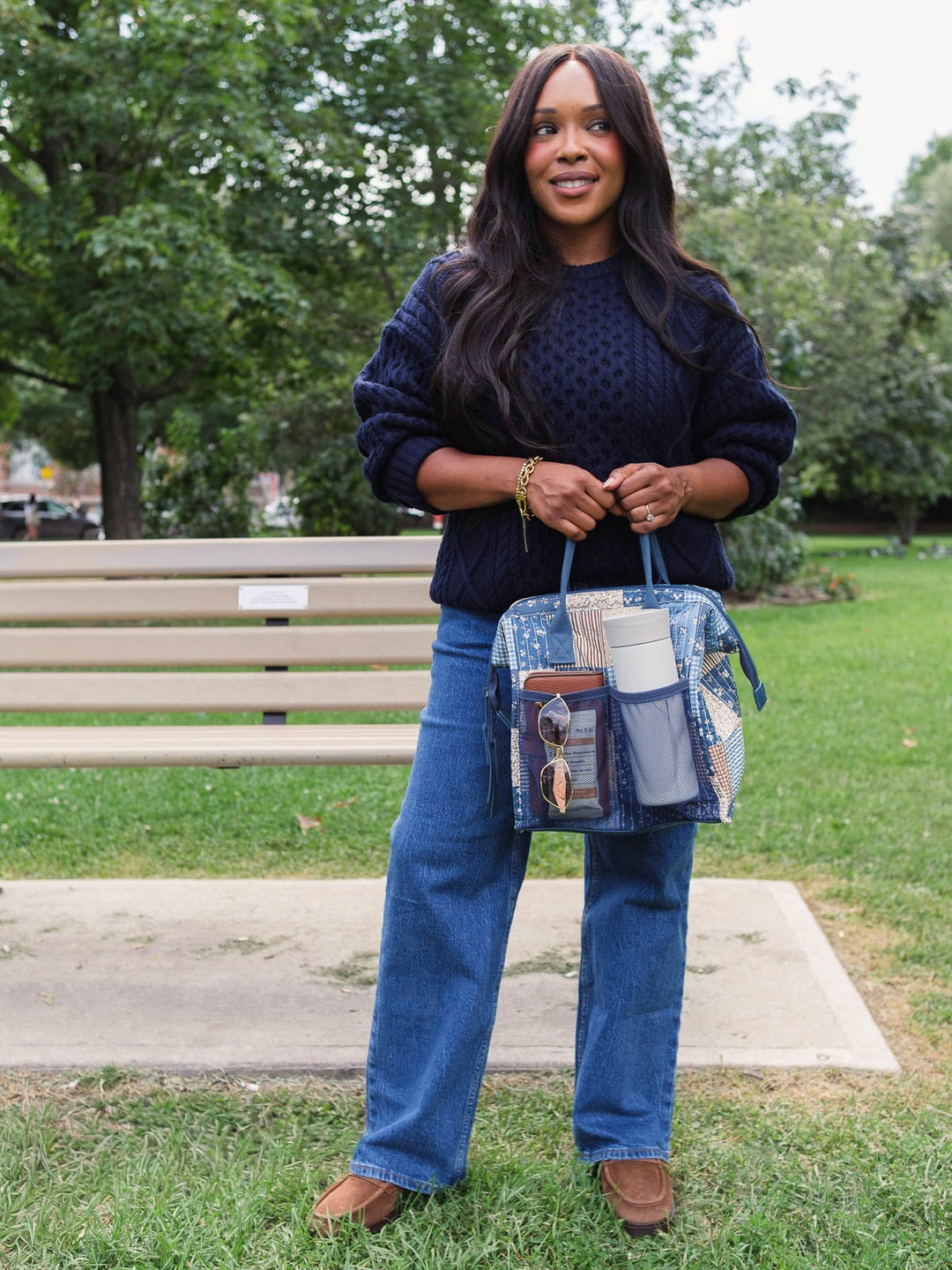 Full-length lifestyle shot of the Poppy & Peonies The Lunch Bag in Navy Patchwork with the front pocket packed, demonstrating its practical storage capacity.