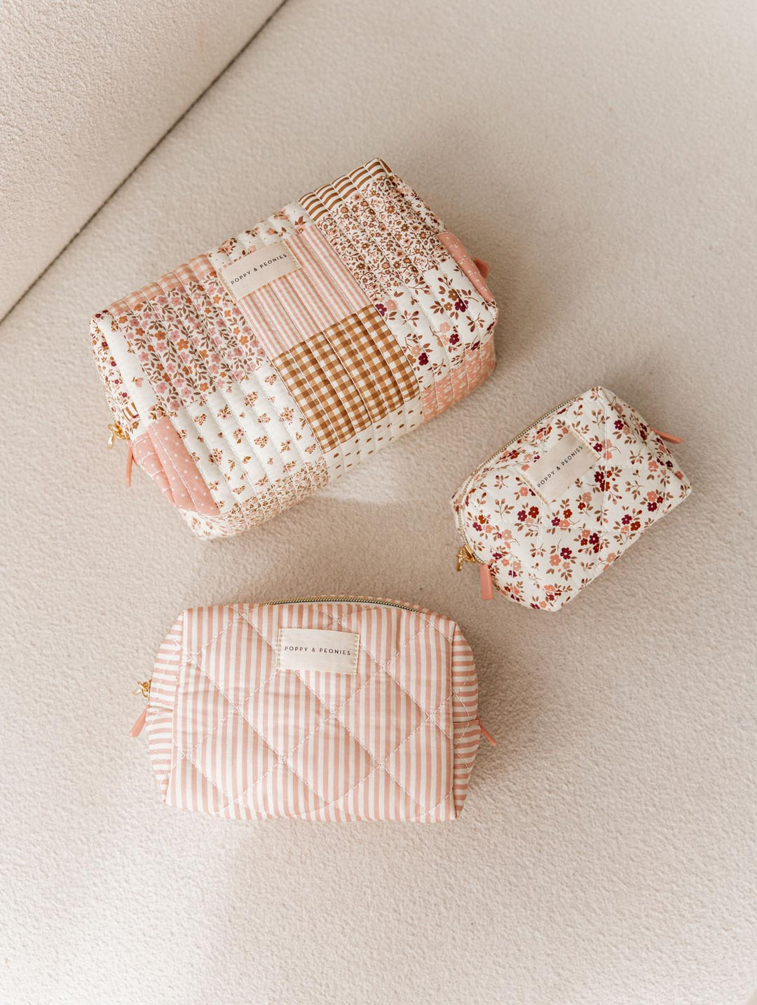 Three fabric makeup bags with floral and checkered patterns on a light background