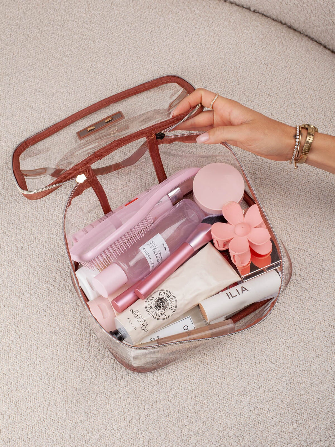 Poppy & Peonies Getaway Cosmetic Set Transparent bag open with cosmetics and beauty essentials inside.