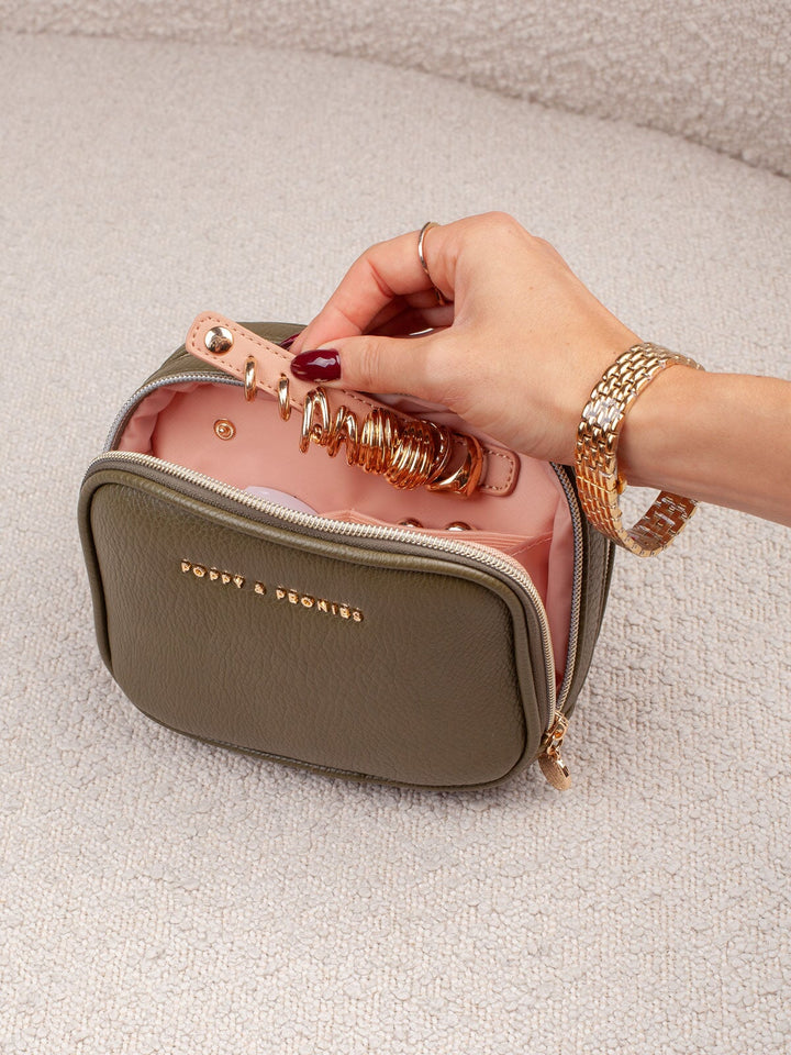 Interior detail of the Poppy & Peonies Pretty Connected Case in Olive, showcasing its dedicated jewelry section with rings and other small jewelry pieces secured inside.