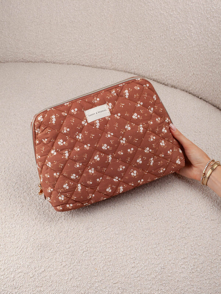 Poppy & Peonies Sitting Pretty Cosmetic Case in Brown Patchwork held by hand.