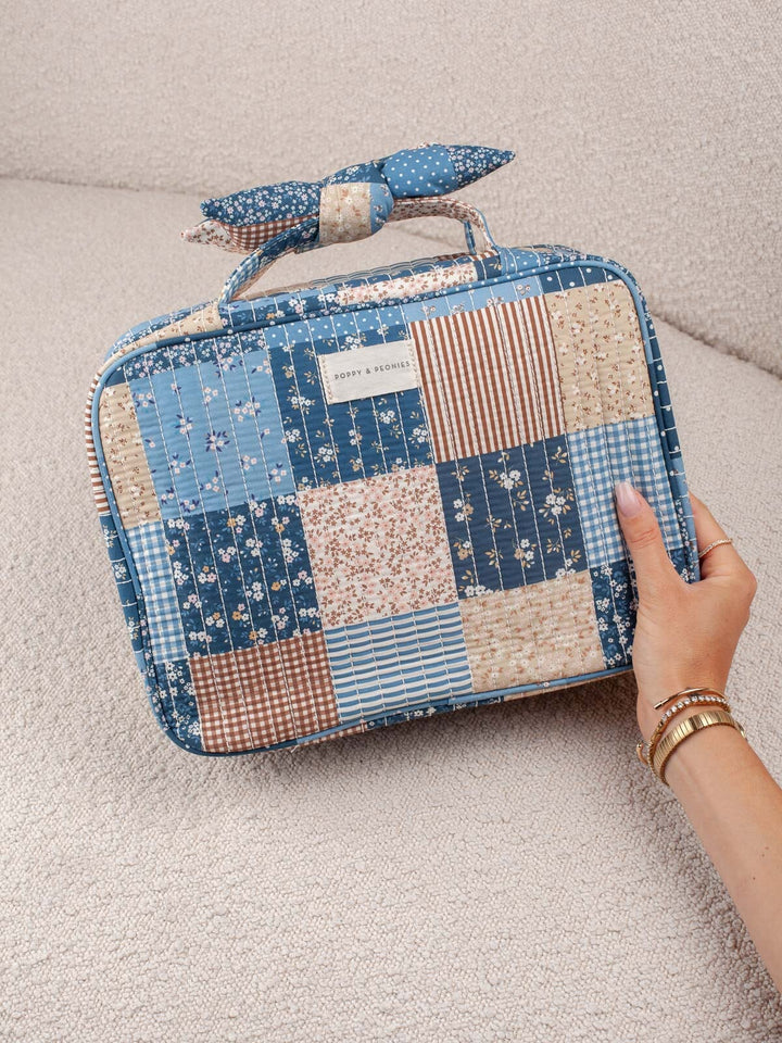 Product-focused lifestyle shot of the Hook Me Up in Navy Patchwork, showcasing its quilted patchwork exterior and convenient top handle.