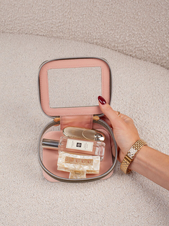Interior lifestyle shot of the Mini I See You in Olive, shown open and filled with beauty essentials. Highlights the clear-view lid, compact interior storage, and easy visibility of everyday cosmetics and accessories.