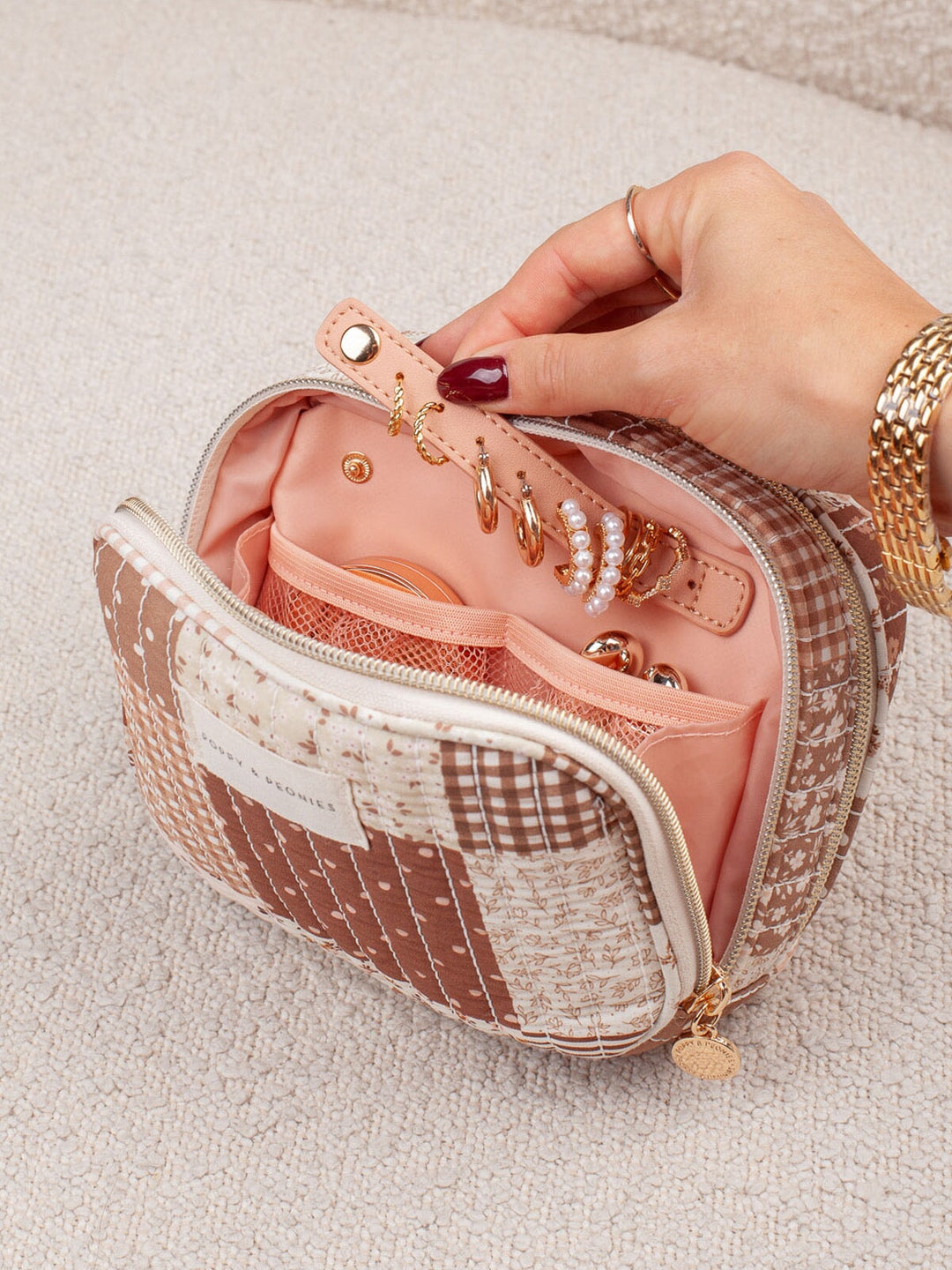 Poppy & Peonies Pretty Connected Case in Brown Patchwork shown open in hand, featuring multiple storage sections for cords, adapters and other compact tech necessities.