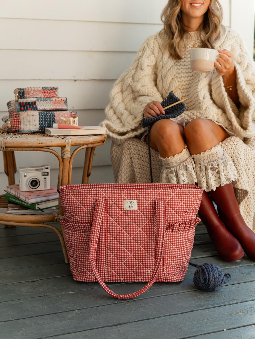 Poppy & Peonies Analog Tote in Heart Berry Gingham lifestyle view, styled beside a woman knitting and holding a mug, with coordinating Strawberry Patchwork cases nearby.