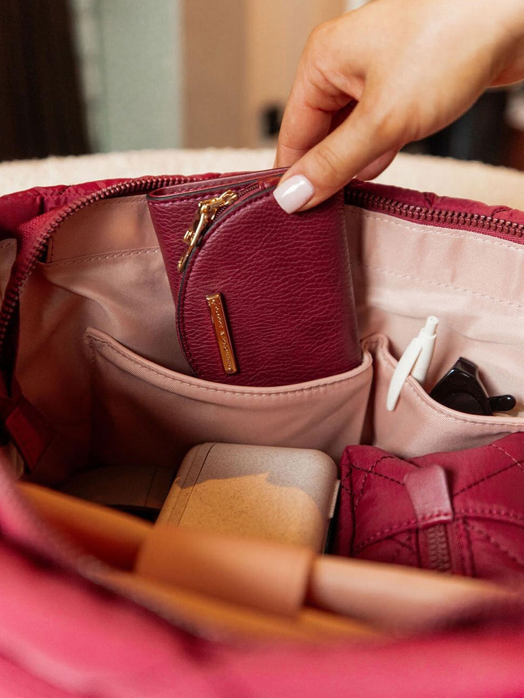 Hand placing a wallet into a quilted bag 