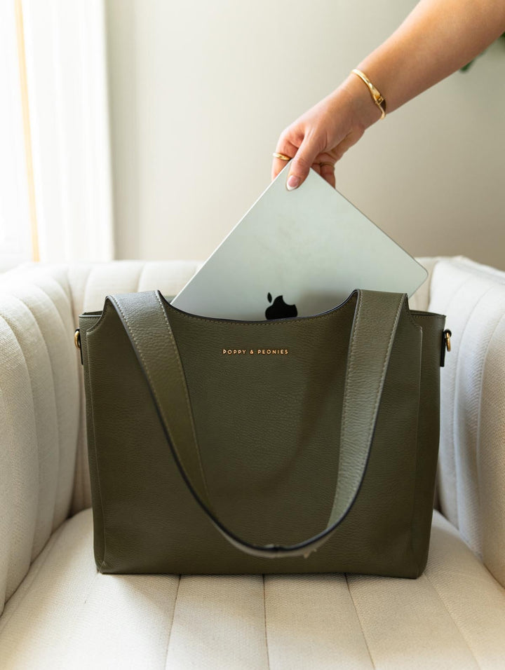 Poppy & Peonies The Companion Tote in Olive lifestyle view, showcasing a laptop being placed into the padded laptop compartment.